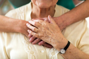 A elderly person with arms wrapped around them